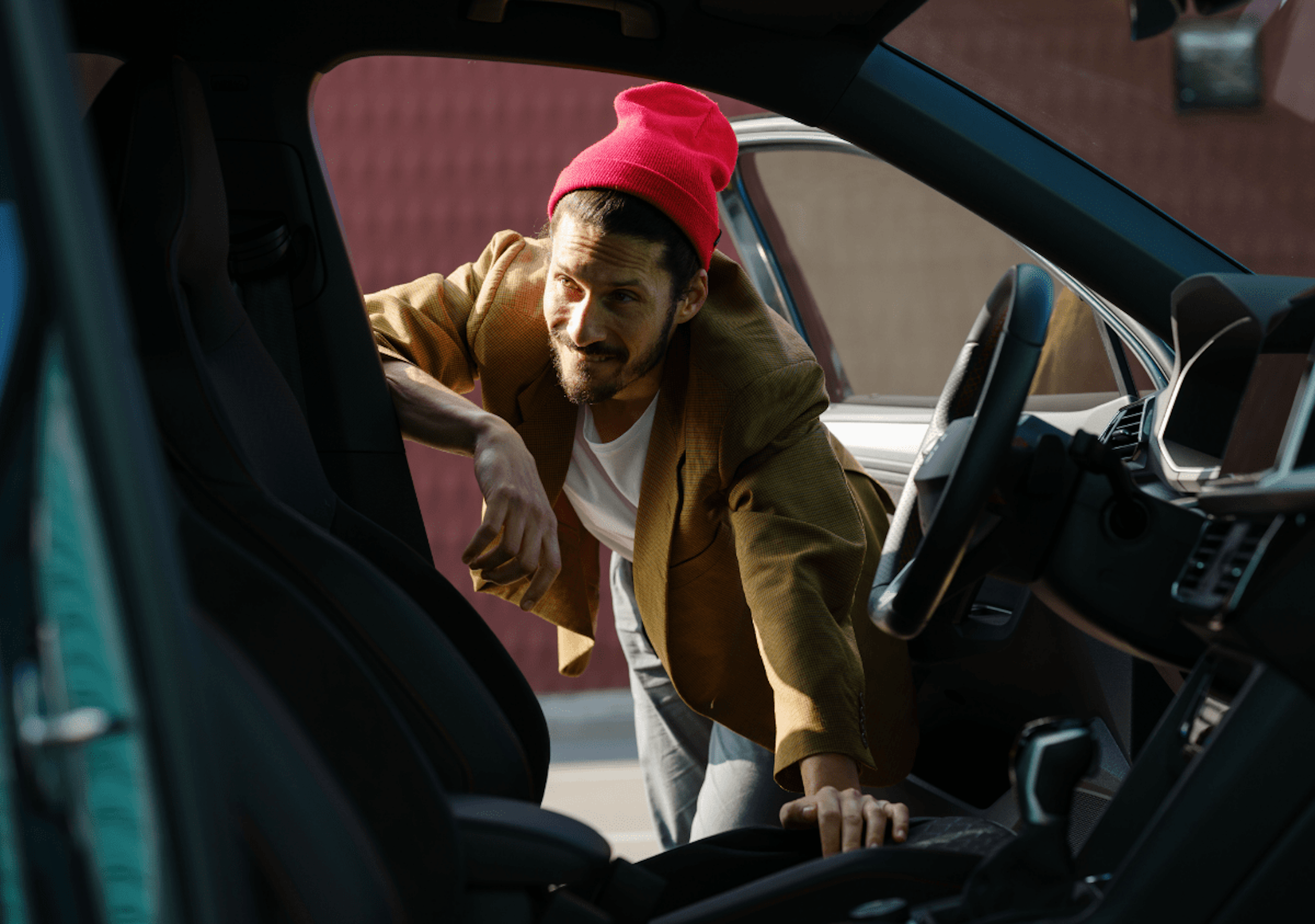 Ein Mann mit roter Mütze lehnt sich in die offene Fahrertür